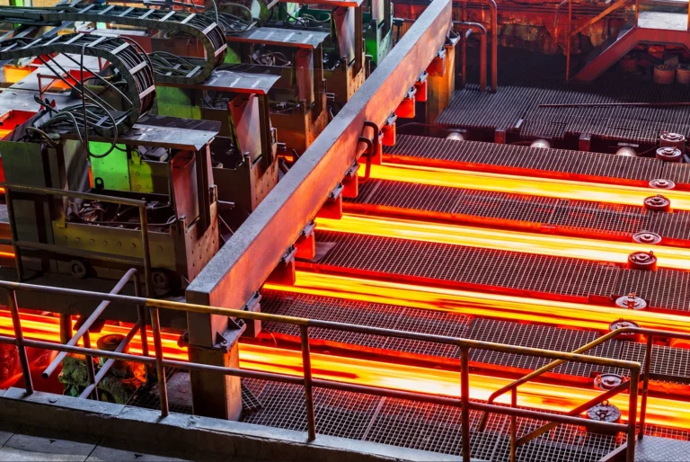 Hot steel billets moving through a steel processing line
