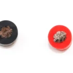 Cut ends of red and black single-core silicone wire, showing the conductors and insulation.